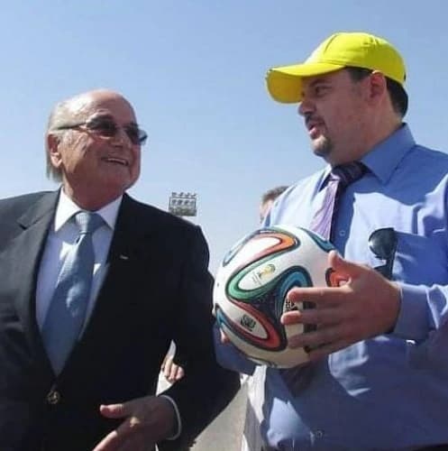 coach rafed holding soccer ball with former FIFA president sepp Blatter